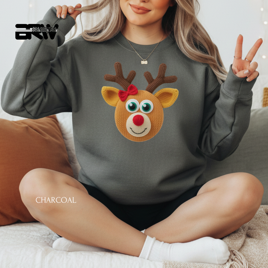 Person wearing a charcoal gray sweatshirt with a reindeer design, sitting on a couch.