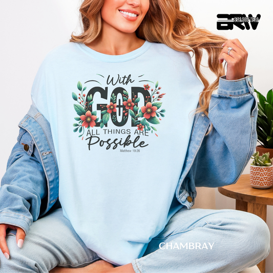 Person wearing a light blue sweatshirt with floral text design, sitting indoors.