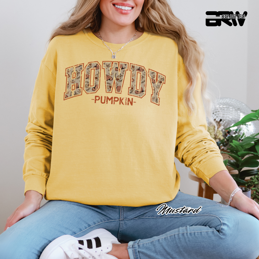 Person wearing a yellow 'HOWDY PUMPKIN' sweatshirt sitting on a couch.