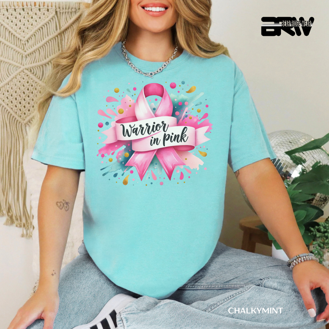 Person wearing a light blue t-shirt with a pink ribbon design and 'Warrior in Pink' text.