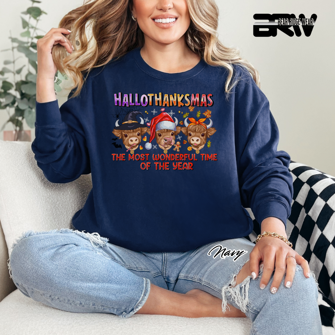 Person wearing a navy blue sweatshirt with 'HALLOTHANKSMAS' design, sitting on a couch.