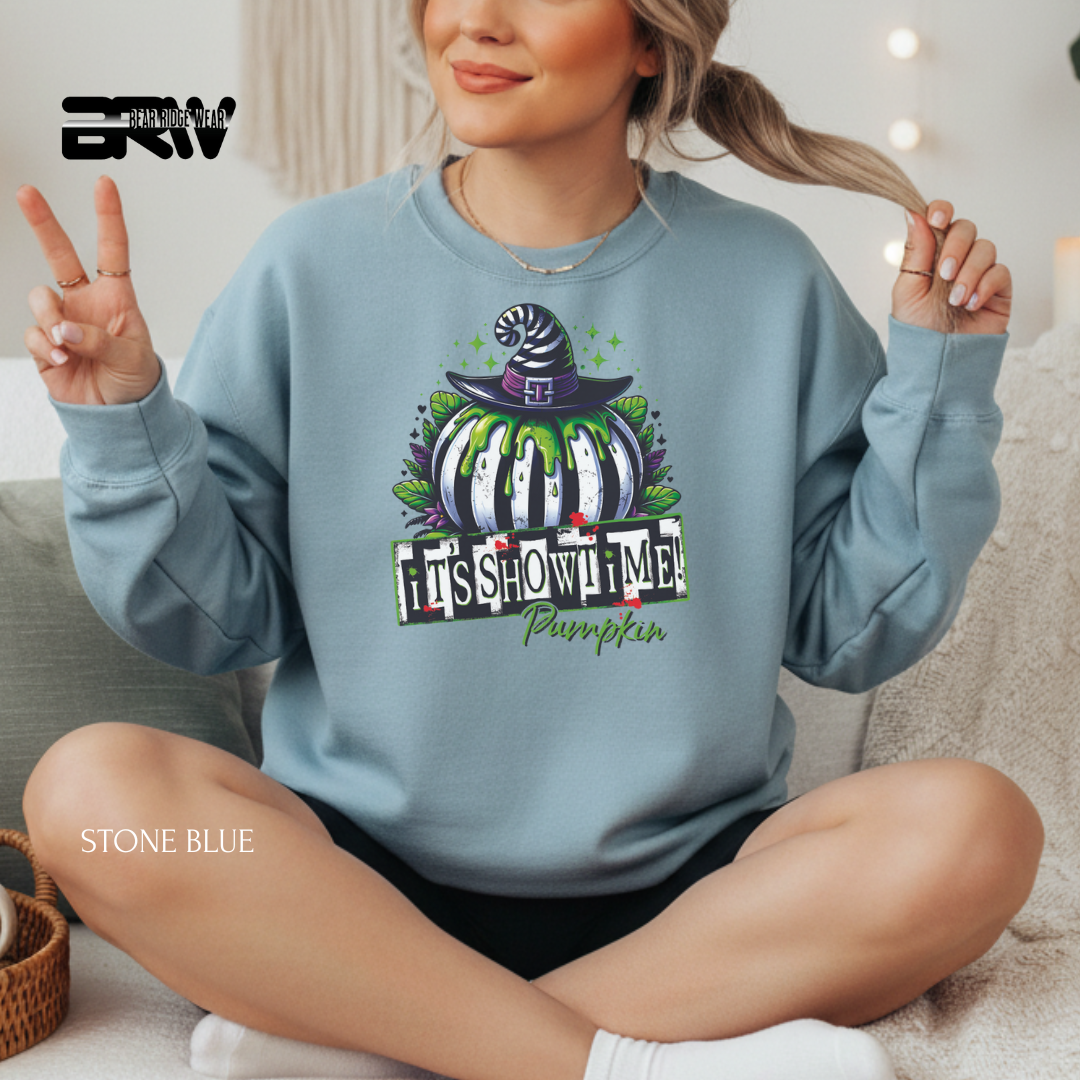 Person wearing a stone blue sweatshirt with a Halloween-themed design, sitting on a couch.