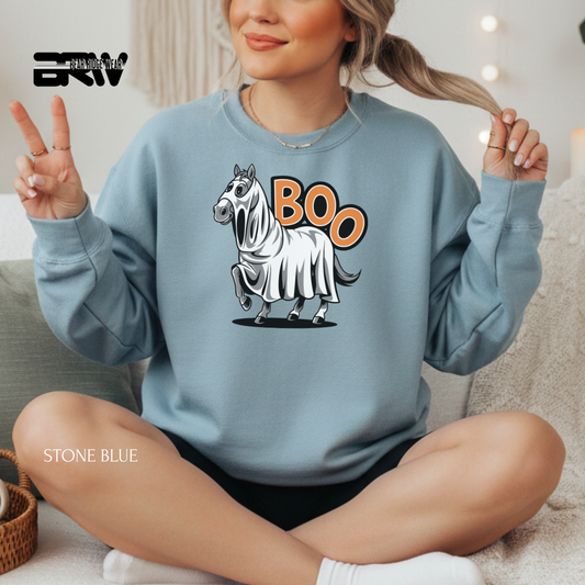 Person wearing a light blue sweatshirt with a zebra graphic and 'BOO' text, sitting on a couch.