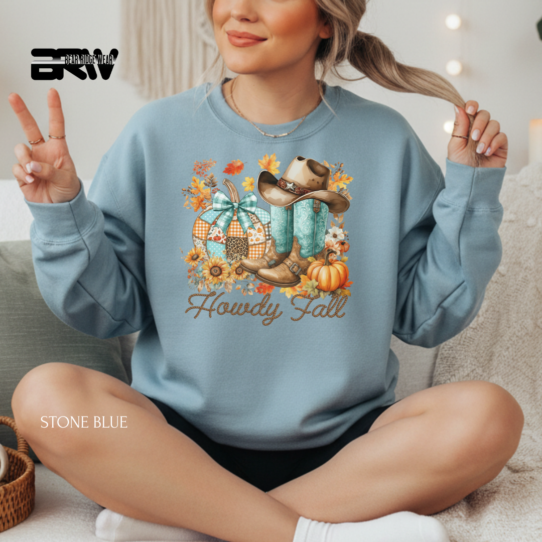 Person wearing a stone blue sweatshirt with fall-themed design and 'Howdy Fall' text.