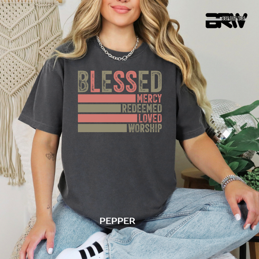 Person wearing a black t-shirt with motivational phrases, sitting in a casual setting.