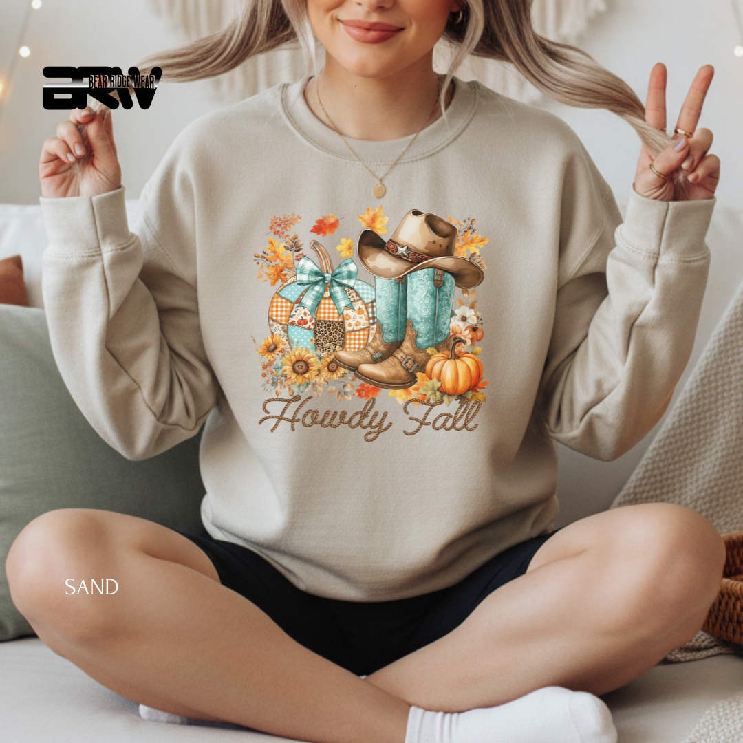 Person wearing a beige sweatshirt with 'Howdy Fall' design, sitting on a couch.