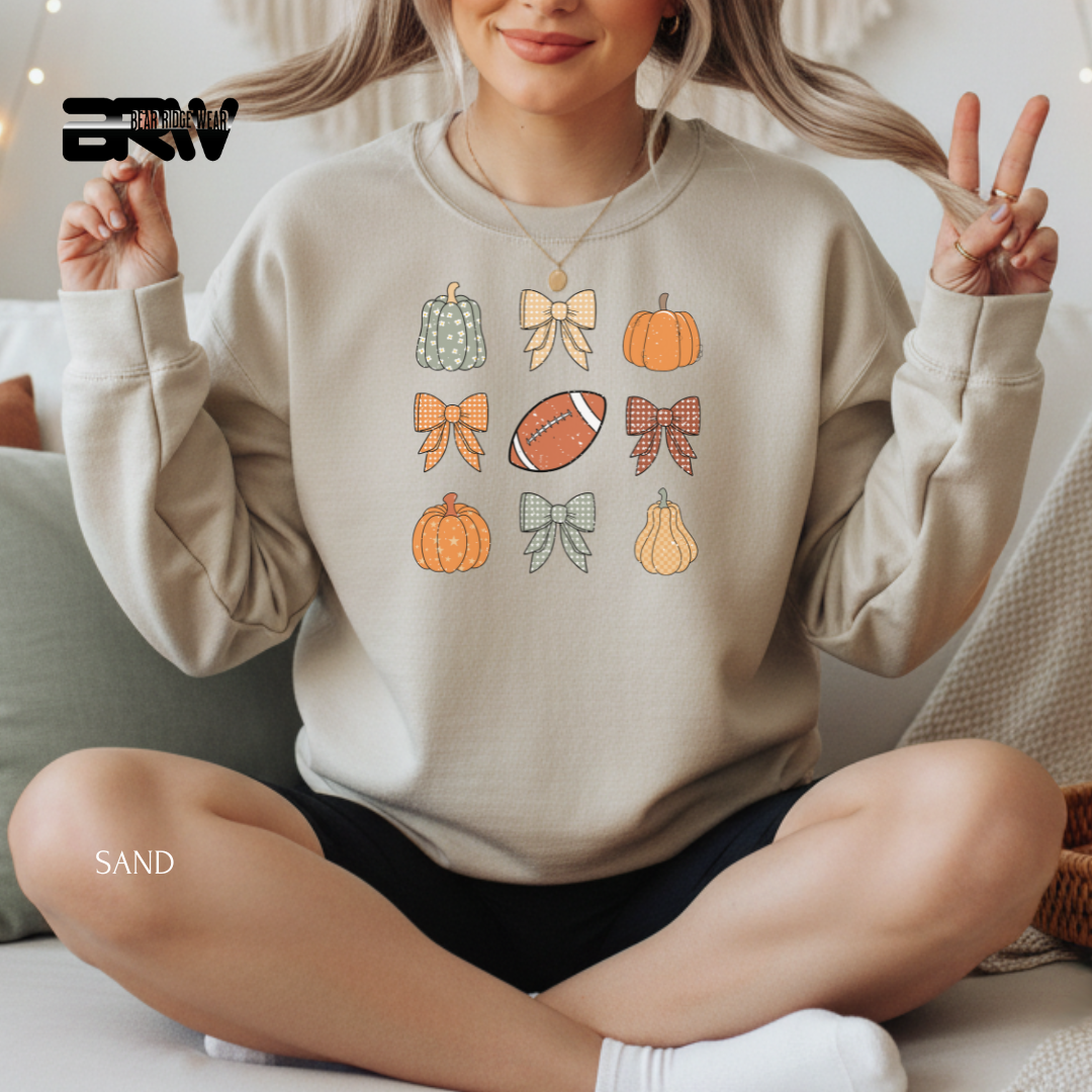 Person wearing a beige sweatshirt with autumn-themed designs, sitting on a couch.