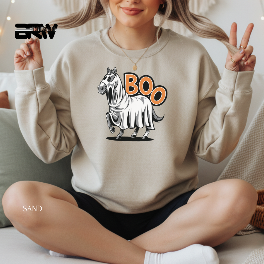 Person wearing a beige sweatshirt with a zebra graphic and 'BOO' text, sitting on a couch.