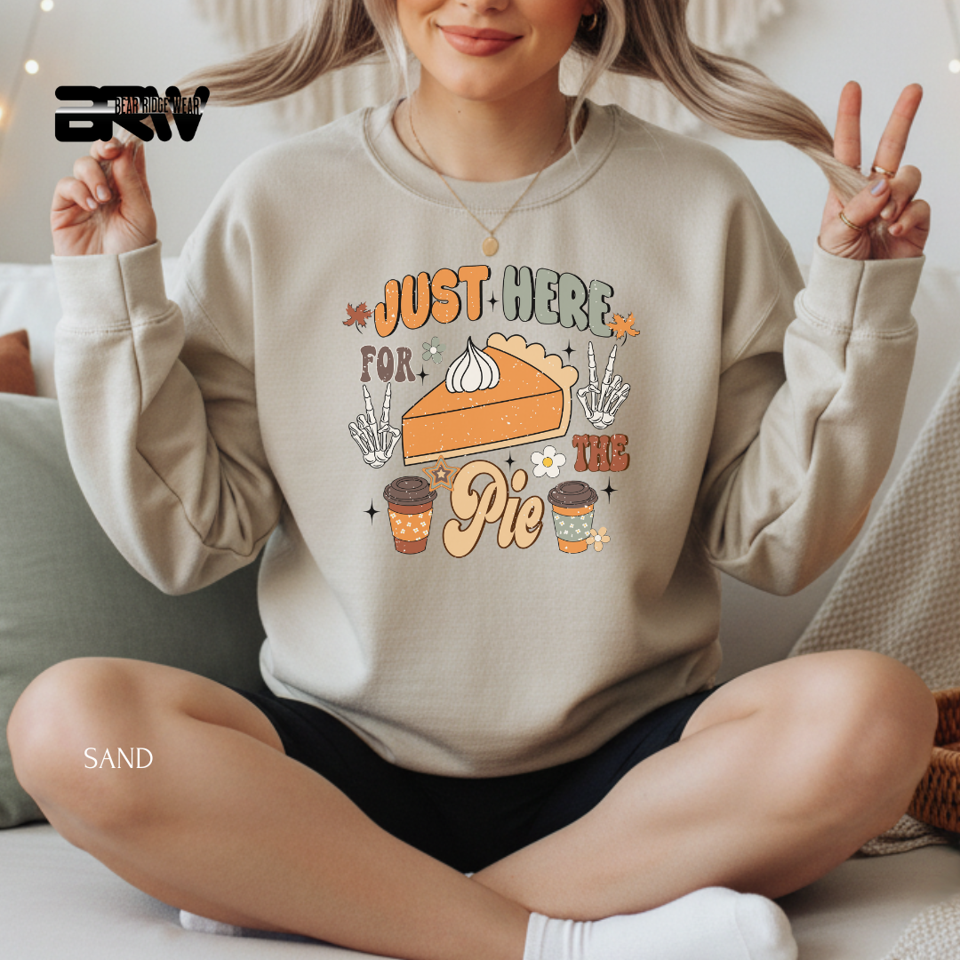 Person wearing a beige sweatshirt with a pie graphic and text, sitting on a couch.