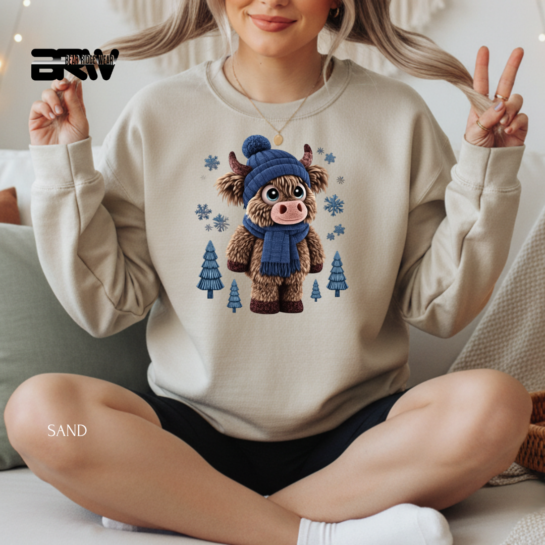 Person wearing a beige sweater with a cartoon cow design, sitting on a couch.