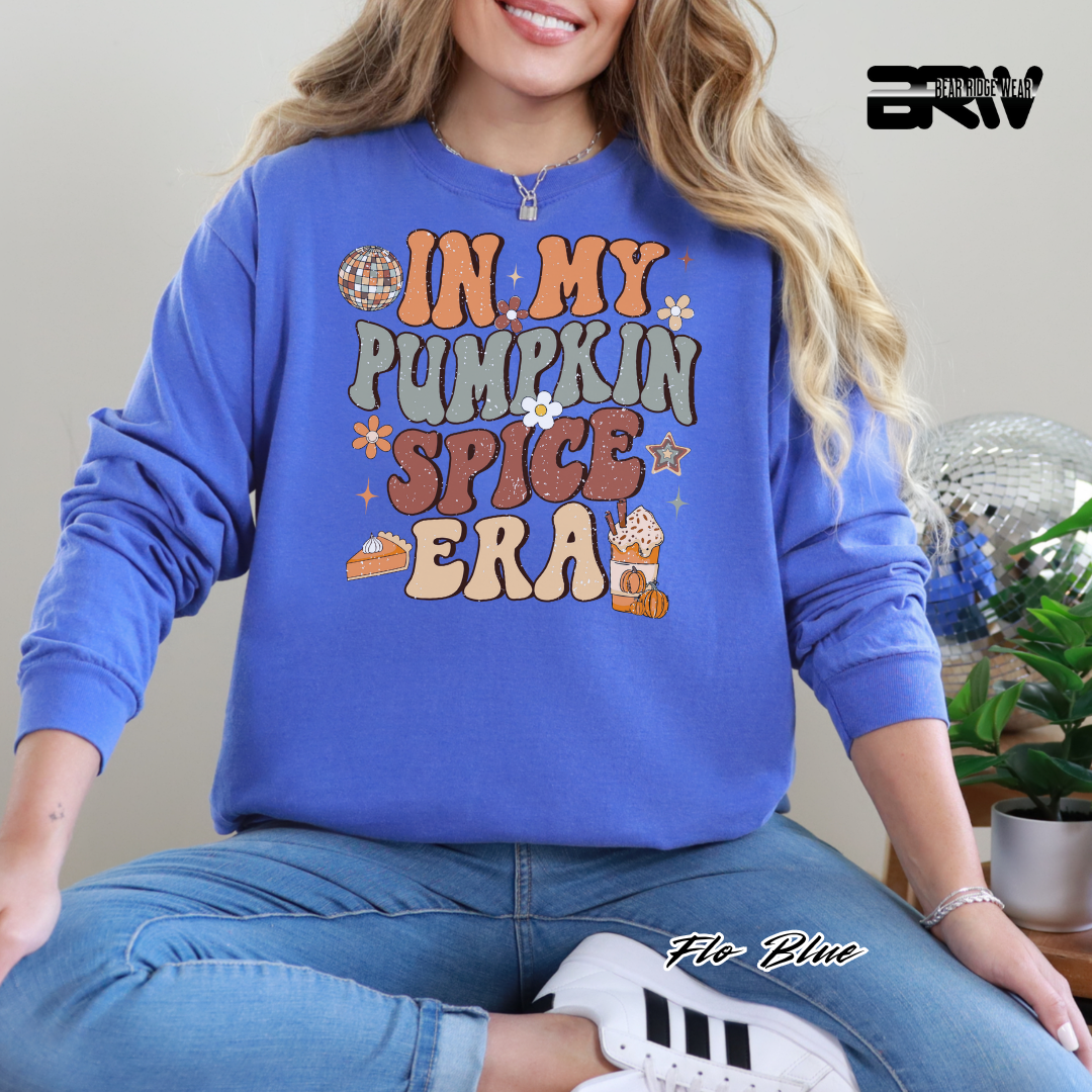 Person wearing a blue sweatshirt with 'In My Pumpkin Spice Era' text, sitting indoors.