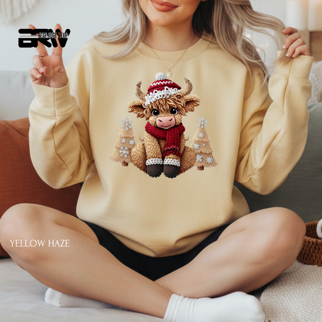 Person wearing a beige sweatshirt with a cow design, sitting on a couch.