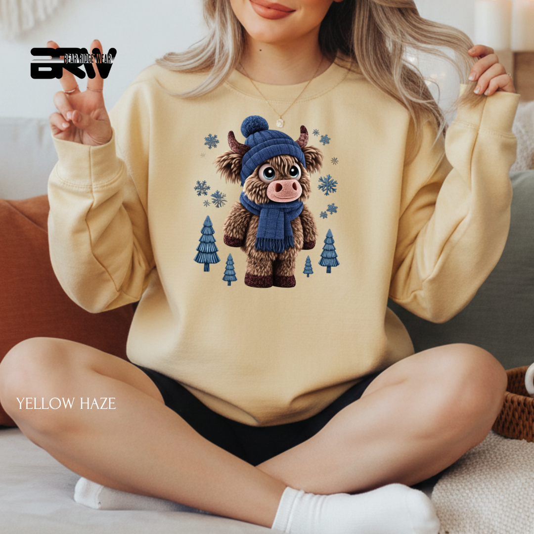 Person wearing a beige sweatshirt with a cartoon cow design, sitting on a couch.