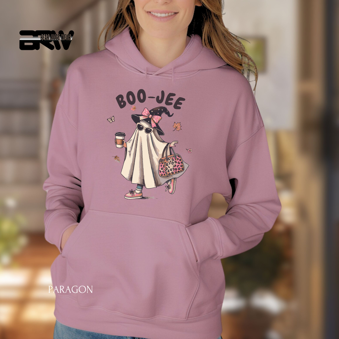 Person wearing a pink hoodie with a cartoon character and 'BOO-JEE' text, blurred indoor background