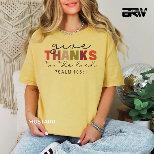 Person wearing a yellow t-shirt with 'give THANKS to the lord' text, sitting in a casual setting.