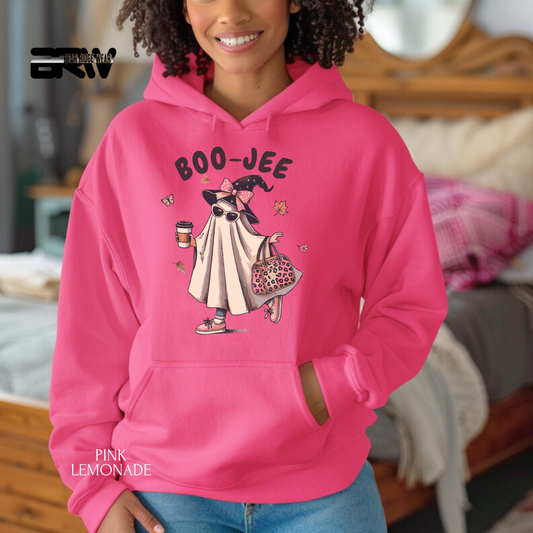 Person wearing a pink hoodie with cartoon character and 'BOO-JEE' text, in a casual indoor setting.