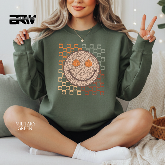 Person wearing a green sweatshirt with a smiley face design, sitting on a couch.