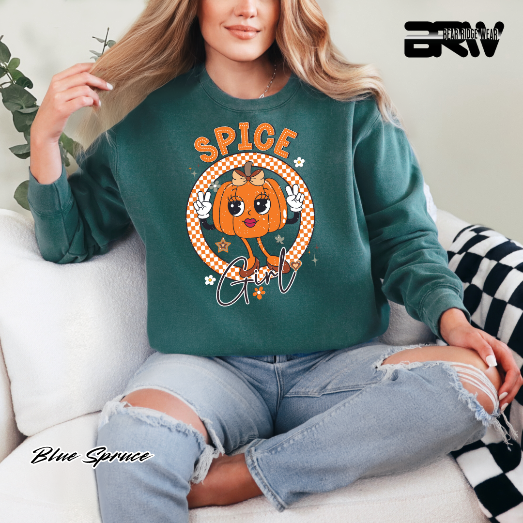 Person wearing a green sweatshirt with a pumpkin design and 'SPICE Girl' text, sitting on a couch.