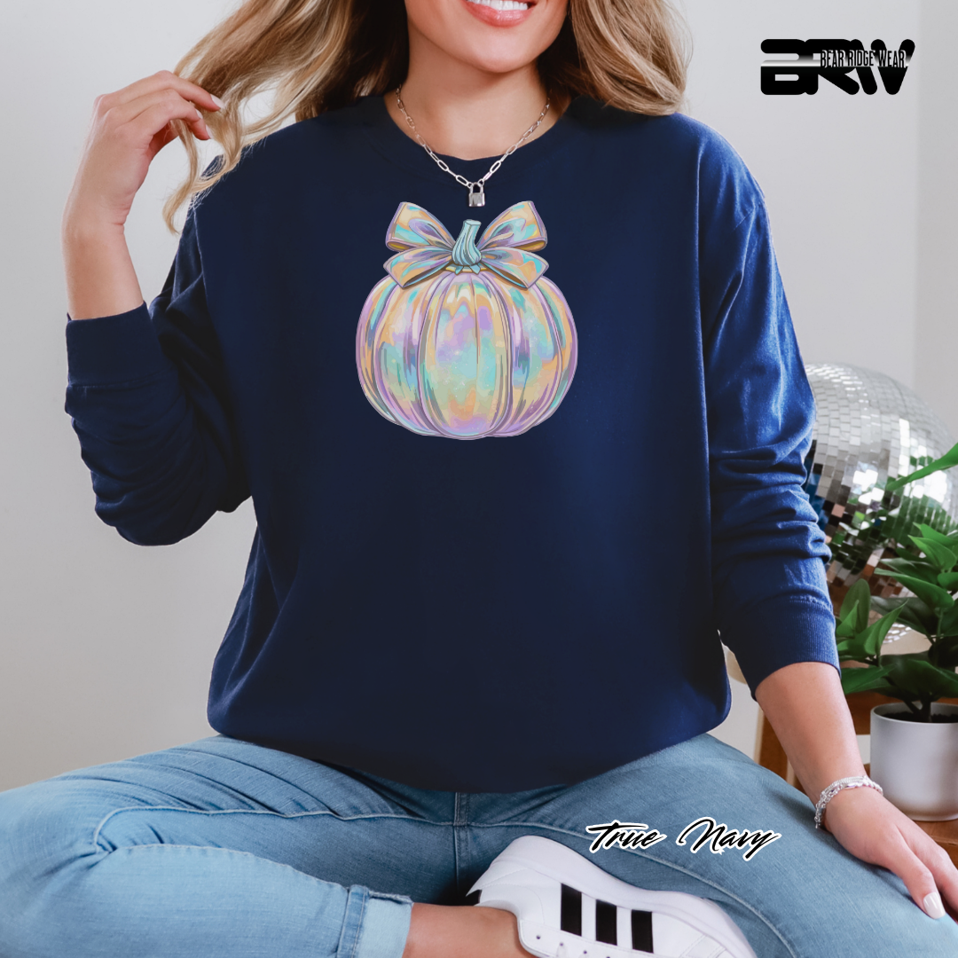 Person wearing a navy sweatshirt with a colorful bow design, sitting indoors. PUMPKIN FALL TEE 