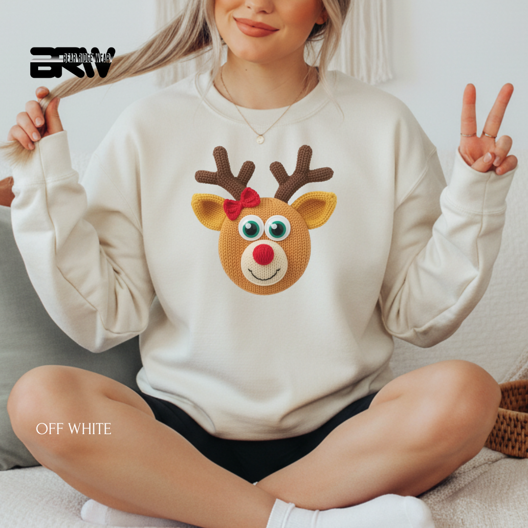 Person wearing a white sweatshirt with a reindeer design, sitting on a couch.