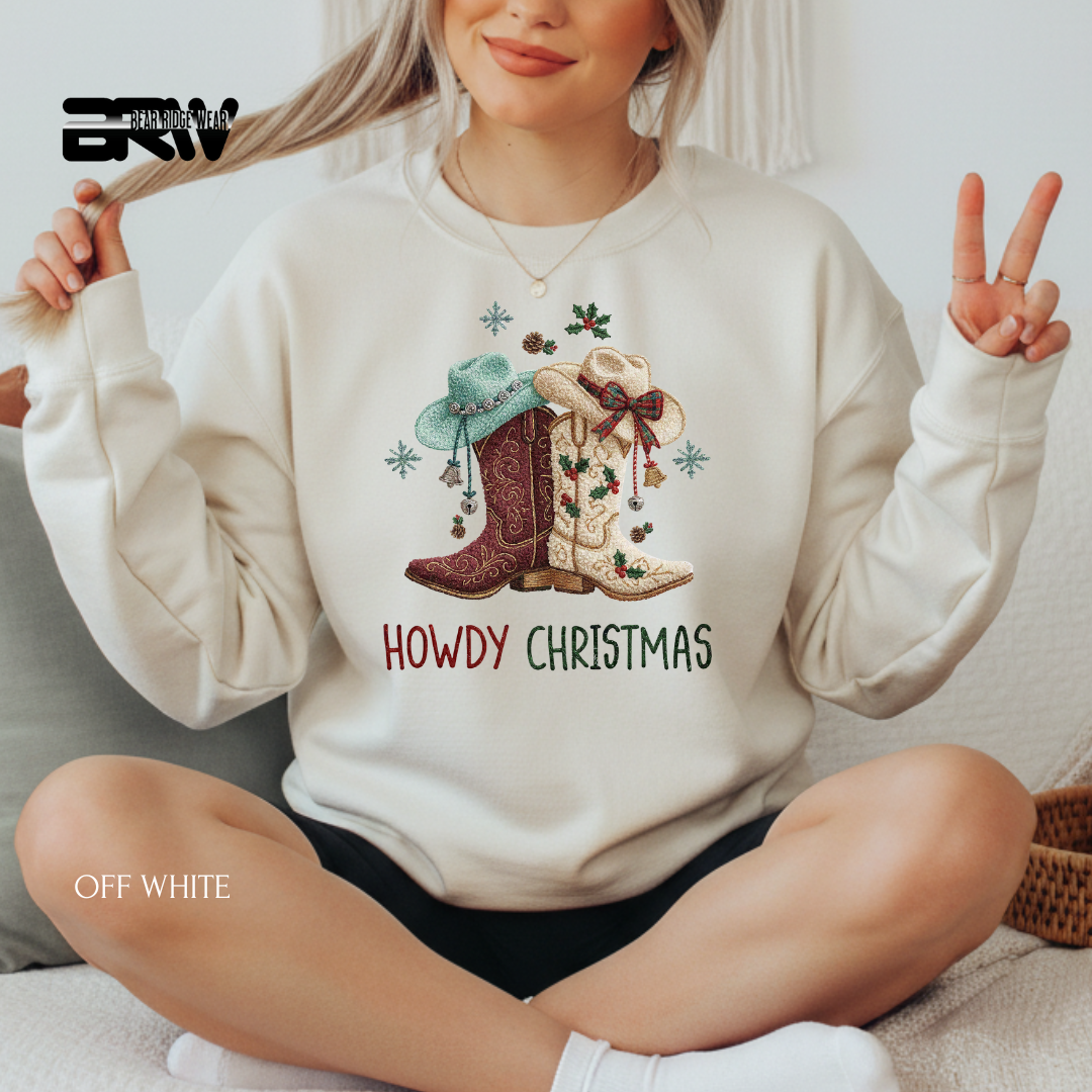 Person wearing a white sweatshirt with 'Howdy Christmas' design, sitting on a couch.
