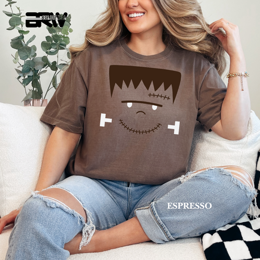 Person wearing a brown t-shirt with a cartoon character design, sitting on a couch.